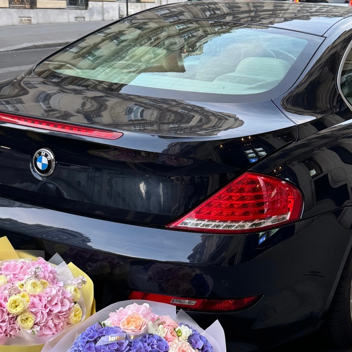 Picture of white roses standing near a black SUV